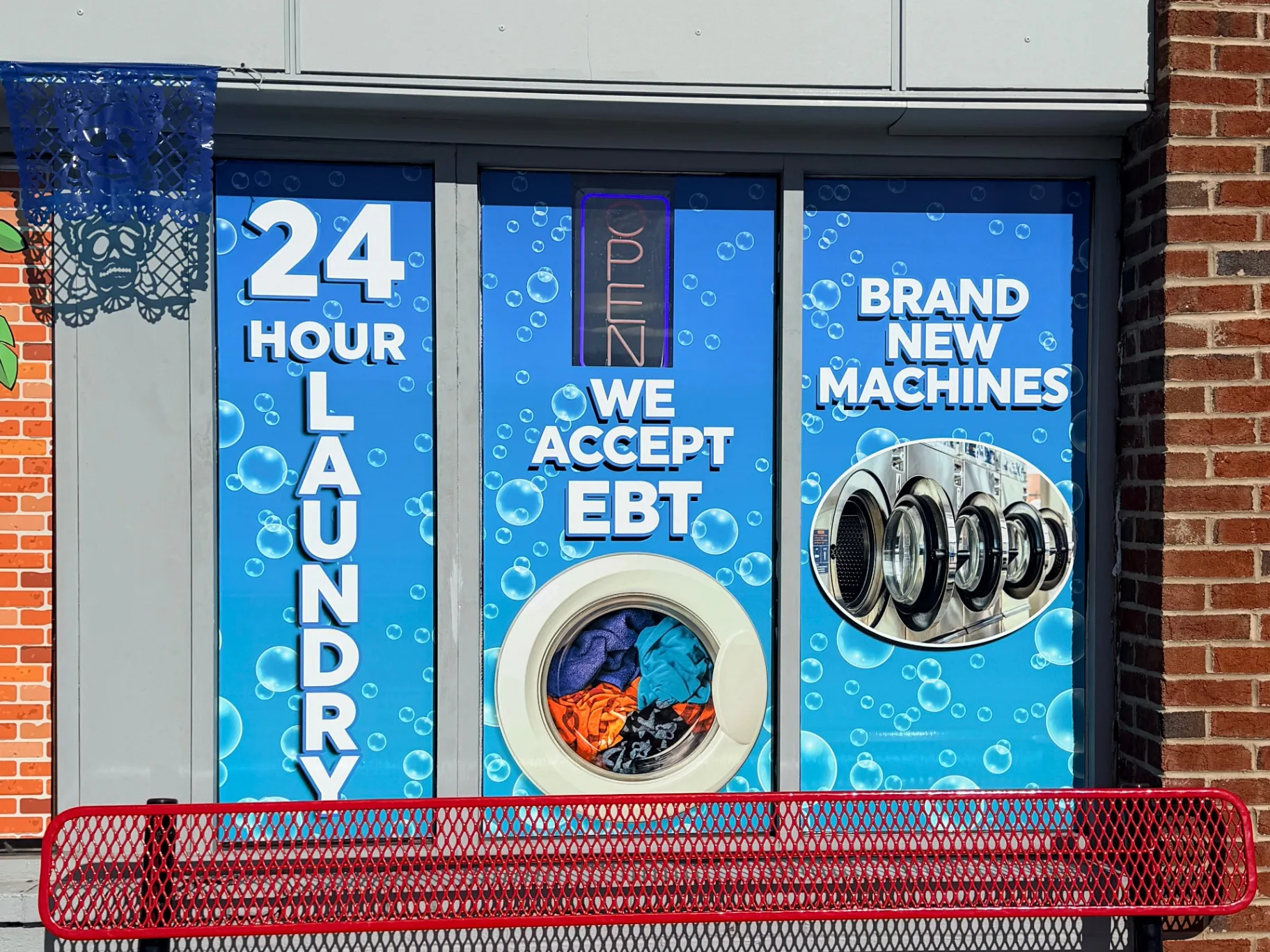 Completed storefront window graphics for a laundromat in northern Delaware